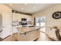 Bright kitchen with white cabinets, granite countertops, and a stainless steel microwave at 12749 Horton Ct, Parker, CO 80134