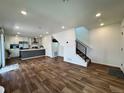 Open concept living room with hardwood floors, staircase, and a view of the modern kitchen at 5060 N Walden Way, Denver, CO 80249