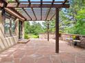 Relaxing patio with a stone privacy wall, pergola, and flagstone pavers at 2107 Ridge Plaza Dr, Castle Rock, CO 80108