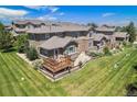 Backyard aerial view featuring wood deck, lush lawn, and mature landscaping at 22002 E Irish Dr, Aurora, CO 80016