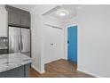 Hallway with modern flooring, coat closet, and view to bright turquoise door at 320 S Ames St # 5, Lakewood, CO 80226
