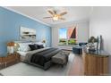 Spacious main bedroom featuring a large window with natural light, stylish furniture, and wood floors at 320 S Ames St # 5, Lakewood, CO 80226