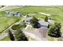 Sprawling aerial shot highlighting the property layout with the home, detached garage, lush greenery, and surrounding fields at 45321 Summit Rd, Parker, CO 80138