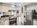 Bright kitchen features granite counters, stainless steel fridge, and modern appliances at 2974 S Parker Ct, Aurora, CO 80014