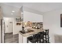 Bright kitchen features granite counters, mosaic backsplash, and an eat-in bar at 2974 S Parker Ct, Aurora, CO 80014