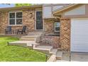 Close-up of the front porch showcasing the entrance, steps, and a small seating area with chairs at 16602 E Gunnison Pl, Aurora, CO 80017