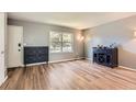 Bright living room featuring modern furnishings, wood-look flooring, and ample natural light from the large window at 16602 E Gunnison Pl, Aurora, CO 80017