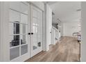 Bright entryway with wood floors, white walls, and glass french doors to the home gym at 4358 S Nepal Ct, Centennial, CO 80015