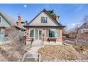 Inviting brick home boasts a peaked roof, large windows, and a meticulously maintained front yard at 1464 S Grant St, Denver, CO 80210