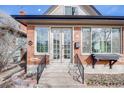 Close-up of a beautiful brick home featuring large windows, a peaked roof, and a charming entryway at 1464 S Grant St, Denver, CO 80210