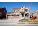 Beautiful two-story home with a three-car garage, inviting covered porch, and well-manicured lawn on a sunny day at 30 Stewart Way, Erie, CO 80516