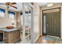 Inviting foyer with a decorative front door, glass paneled sidelight, hardwood floors, and an adjacent office at 30 Stewart Way, Erie, CO 80516