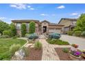 The exterior of a ranch-style home with a landscaped front yard and brick walkway at 10443 Skyreach Way, Highlands Ranch, CO 80126