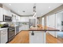 Bright kitchen featuring a kitchen island with a wooden bar top, stainless steel appliances, and modern white cabinets at 1630 N Clarkson St # 110, Denver, CO 80218