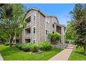 Multi-level condo building featuring stone and siding, plus green lawn at 8378 S Upham Way # B205, Littleton, CO 80128