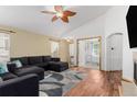 Spacious living room with a ceiling fan, wood flooring, and a cozy seating area with a dark gray sectional at 16257 E 105Th Cir, Commerce City, CO 80022