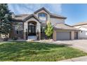 Attractive brick home featuring a well-kept lawn, charming entrance, and a spacious garage, offering comfortable living at 9629 Silent Hills Ln, Lone Tree, CO 80124