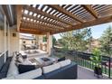 Inviting covered deck features a lounge area with a fireplace and outdoor kitchen with bar seating at 9629 Silent Hills Ln, Lone Tree, CO 80124