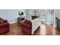 Living room with hardwood floors, a red couch, and a flat-screen TV at 2808 S Fundy St, Aurora, CO 80013