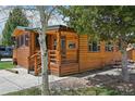 Well-kept log cabin with inviting covered porch, accented by mature trees and landscaping at 85 Revett Dr # 40, Breckenridge, CO 80424