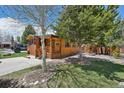 Cozy log cabin with a covered porch, surrounded by lush greenery and mature trees at 85 Revett Dr # 40, Breckenridge, CO 80424