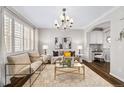 Elegant living room featuring a decorative chandelier, neutral paint, a window with shutters, and hardwood floors at 7422 E 7Th Ave # 14, Denver, CO 80230