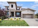 Charming two-story home featuring stone accents, a well-manicured lawn, and an attached two-car garage at 11898 Discovery Cir, Parker, CO 80138