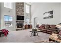 Spacious living room with a stone fireplace and leather furniture at 11898 Discovery Cir, Parker, CO 80138