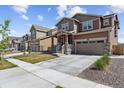 Attractive two-story home showcasing a neat front yard, stone accents, and a spacious two-car garage at 13221 E 110Th Pl, Commerce City, CO 80022