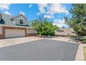 Spacious driveway and well-maintained exterior of a charming townhome on a sunny day at 12502 E Harvard Cir, Aurora, CO 80014
