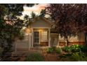 Inviting front entrance with decorative gate, mature landscaping, and charming architectural details at 12502 E Harvard Cir, Aurora, CO 80014