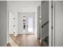 Bright entryway with hardwood floors, white walls, and staircase with black handrail and gray carpet at 5584 Moosehead Cir, Longmont, CO 80504