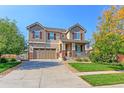 Charming two-story home boasting a well-manicured lawn, mature trees, and inviting front porch with stone accents at 16021 Williams Pl, Broomfield, CO 80023