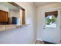 The entrance to the house is a white door, with a view of the kitchen at 1240 S Idalia St, Aurora, CO 80017