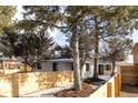 Well-manicured exterior with wooden fence and mature trees showcasing great curb appeal at 1360 Wolff St, Denver, CO 80204