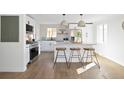 Modern kitchen with stainless steel appliances, light countertops, and a stylish island with stool seating at 1360 Wolff St, Denver, CO 80204