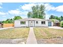Charming ranch home with white exterior, blue trim, and well-maintained front yard at 6500 W 32Nd Ave, Wheat Ridge, CO 80033