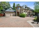 Charming stone home with a circular tower, three car garage and brick driveway at 2891 E Alameda Ave, Denver, CO 80209