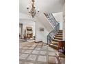 Elegant foyer with staircase, chandelier and view of the fireplace in the living room at 2891 E Alameda Ave, Denver, CO 80209
