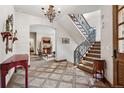 Grand foyer with beautiful tile flooring, chandelier and wrought iron staircase at 2891 E Alameda Ave, Denver, CO 80209