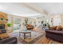 Bright living room with a stone fireplace, hardwood floors, and access to the outdoor patio at 42 S Moline St, Aurora, CO 80012