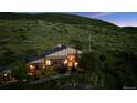 Inviting hillside home with warm interior lights and beautiful landscaping at twilight at 2605 Cactus Cir, Golden, CO 80401