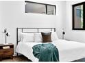 Comfortable bedroom with modern decor, including stylish lighting, a plush bed, and contemporary windows at 1601 Park Ave # 212, Denver, CO 80218