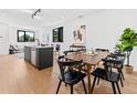 Elegant dining area adjacent to the kitchen, featuring a wooden table, black chairs, and hardwood floors at 1601 Park Ave # 212, Denver, CO 80218