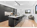 Open-concept kitchen with island seating flows into a bright living space, featuring sleek design and modern finishes at 1601 Park Ave # 212, Denver, CO 80218