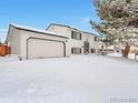 Charming two-story home with a two-car garage covered in snow at 9135 W Maplewood Ave, Littleton, CO 80123