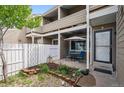 Cozy, covered patio with outdoor seating, a well-kept garden bed, and a white picket fence at 8095 E Colorado Ave # 5, Denver, CO 80231