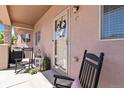 Welcoming front porch featuring rocking chairs, decorative wreath, and a covered entrance at 15501 E 112Th Ave # 20C, Commerce City, CO 80022