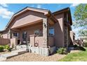 Inviting front porch with stone accents, covered entry, and well-maintained landscaping at 15501 E 112Th Ave # 20C, Commerce City, CO 80022