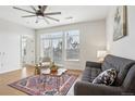 Cozy living room with a large window, ceiling fan, modern furniture, and a decorative area rug at 13456 Via Varra # 211, Broomfield, CO 80020